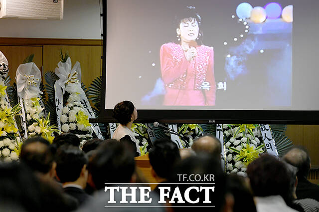 고인의 생전 활동 모습을 바라보는 고인의 가족과 동료들.