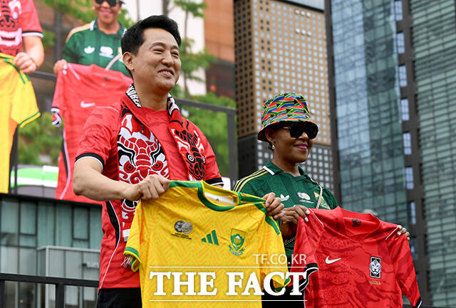 오세훈 서울시장(왼쪽)이 대한민국과 남아프리카 공화국의 2026 국제축구연맹(FIFA) 북중미월드컵 조별리그 A조 3차전 경기가 열린 25일 오전 서울 종로구 광화문광장을 찾아 음쿠쿠 주한남아프리카 공화국 대사와 유니폼을 교환한 뒤 응원을 하고 있다. /박상민 기자