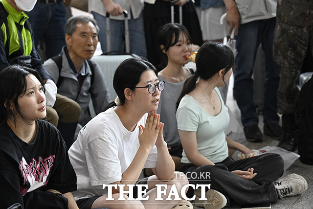 한 시민이 두 손을 모은 채 경기를 보고 있다.