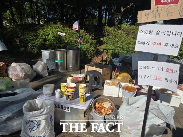 전날 서울 송파구 올림픽공원 핸드볼경기장 1-1 출입구 인근에 컵라면 용기와 음식물 쓰레기가 쌓여 있다. 안내문에는 '소중한 음식입니다. 쓰레기 줄여주세요' 문구가 적혔다. /안디모데 기자