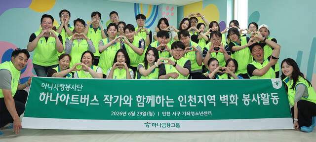 하나금융그룹은 지난 29일 인천 서구 소재 가좌청소년센터에서 발달장애인 예술가들을 위한 미술공모전 '하나 아트버스' 수상자와 함께 벽화 조성 봉사활동을 실시했다. 이날 봉사활동에 참여한 하나금융그룹 임직원들이 발달장애인 예술가 강원진 작가(첫번째 줄 왼쪽에서 다섯번째)와 함께 벽화 그리기를 마치고 기념촬영을 하고 있다. /하나금융그룹
