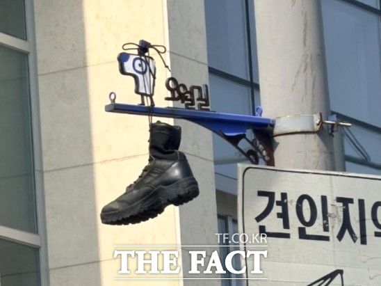 전남광주시 동구 구 시외버스터미널 인근 교차로 5월길 안내 표지판에 군화가 끈으로 묶여 매달려 있다. /5·18기념재단