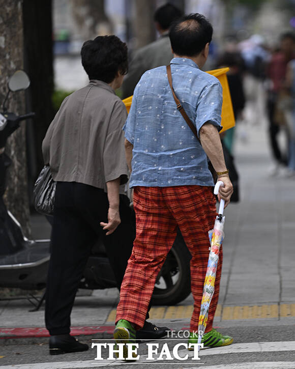 우산을 접은 채 걷고 있는 시민.
