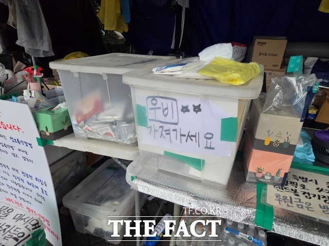 지난 9일 올림픽공원 핸드볼경기장 1-3 출입구 인근 물품 나눔소에서 우비를 무료로 나눠주고 있다. /안디모데 기자
