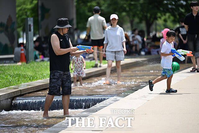 한 부자가 물총놀이를 하고 있다.