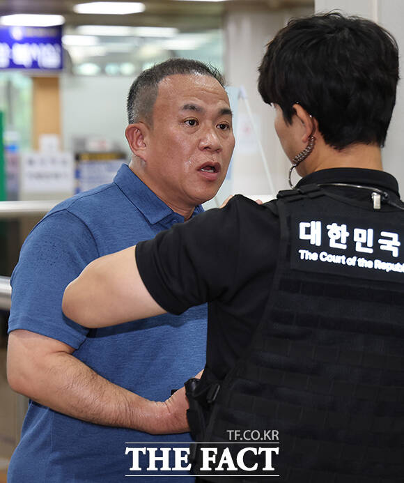 정치 브로커 명태균 씨가 13일 오전 서울 서초구 서울중앙지법에서 열린 무상 여론조사 수수 사건에 대한 선고 공판에 출석하고 있다. /사진공동취재단