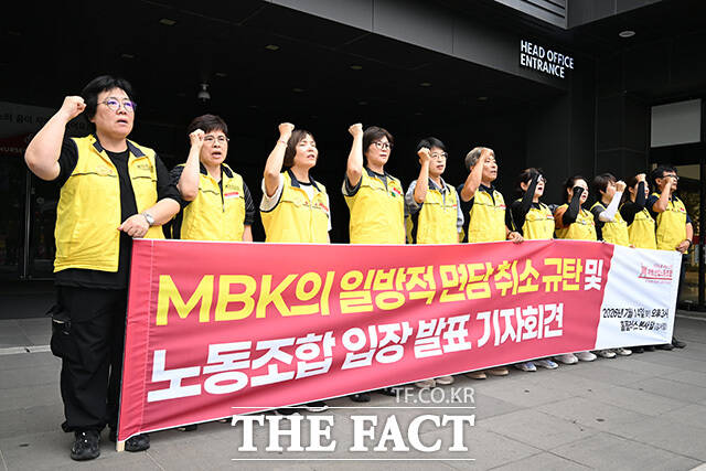 노조원들이 기자회견을 마친 후 면담 연기 규탄 대자보를 붙이고 있다.