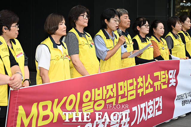 노조원들이 기자회견을 마친 후 면담 연기 규탄 대자보를 붙이고 있다.