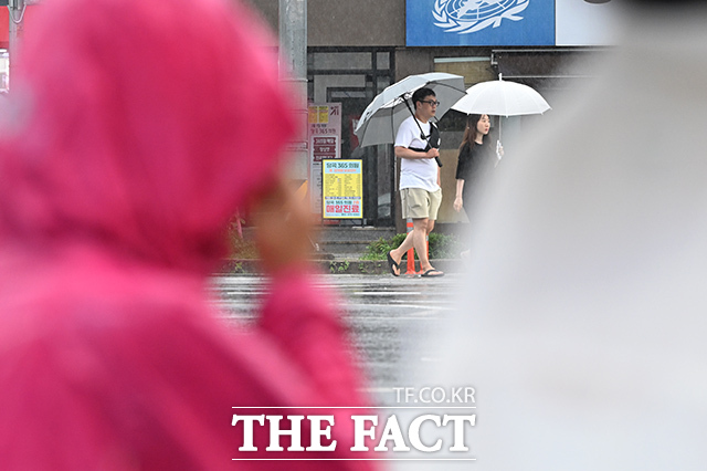 밤 사이 많은 비가 예보된 14일 오후 서울 관악구 당곡사거리에서 시민들이 우산을 쓴 채 발걸음을 재촉하고 있다. /김성렬 기자