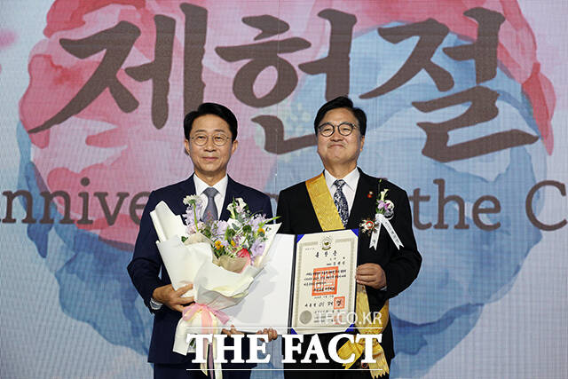 우원식 전 국회의장이 국민훈장 무궁화장을 전수받은 뒤 기념사진 촬영을 하고 있다.