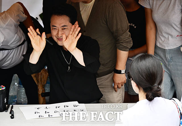 장동혁 국민의힘 대표가 17일 오후 서울 송파구 올림픽공원 핸드볼경기장 앞에서 시위 참가자들에게 손피켓을 제작해 주고 있다. /배정한 기자