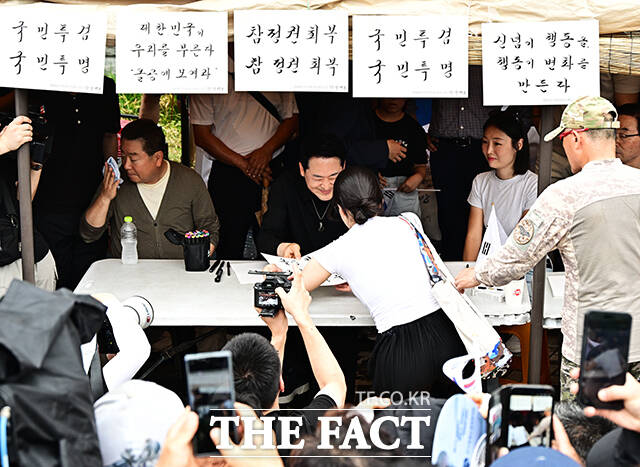 장동혁 국민의힘 대표가 17일 오후 서울 송파구 올림픽공원 핸드볼경기장 앞에서 시위 참가자들에게 손피켓을 제작해 주고 있다. /배정한 기자