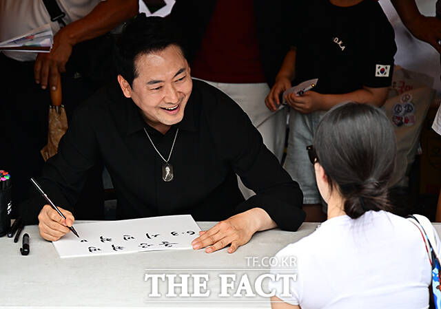장동혁 국민의힘 대표가 17일 오후 서울 송파구 올림픽공원 핸드볼경기장 앞에서 시위 참가자들에게 손피켓을 제작해 주고 있다. /배정한 기자