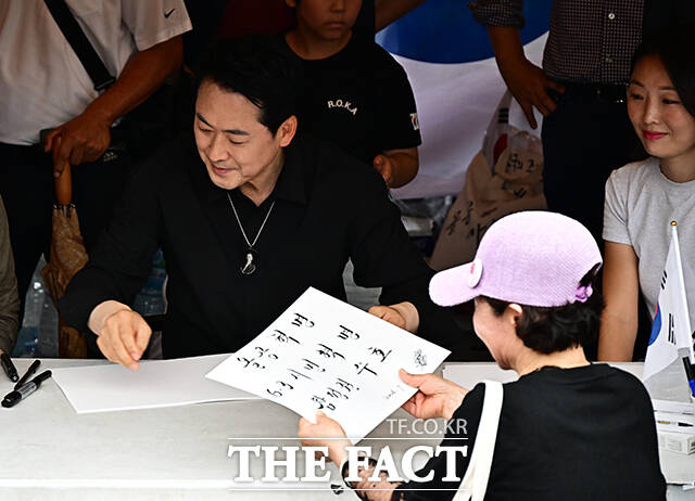 장동혁 국민의힘 대표가 17일 오후 서울 송파구 올림픽공원 핸드볼경기장 앞에서 시위 참가자들에게 손피켓을 제작해 주고 있다. /배정한 기자