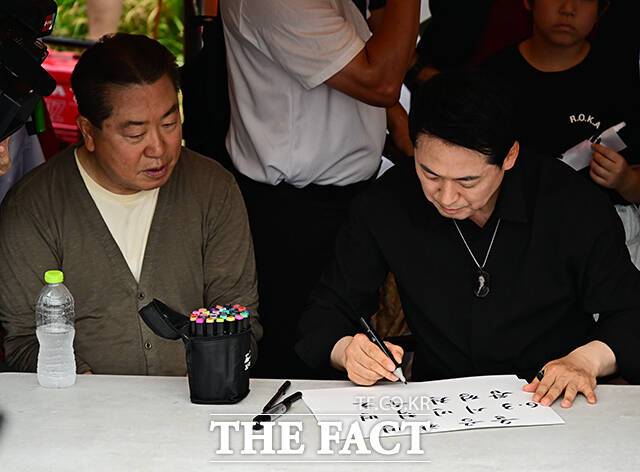 장동혁 국민의힘 대표가 17일 오후 서울 송파구 올림픽공원 핸드볼경기장 앞에서 시위 참가자들에게 손피켓을 제작해 주고 있다. /배정한 기자