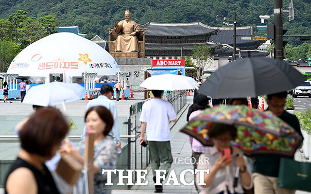 밤사이 내린 비가 소강상태를 보인 18일 오후 서울 종로구 광화문 광장 일대 분수에서 한 아이가 물놀이하고 있다. /박상민 기자