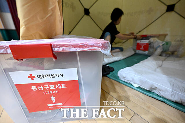 쿠팡32물류센터 화재 이틀째인 19일 오후 인천 서해구 신현초등학교 체육관에 임시 대피소가 운영되고 있는 가운데 한 주민이 응급구호세트를 살펴보고 있다. /인천=박상민 기자
