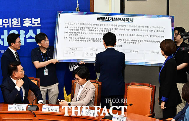 공명선거실천서약서에 서명하는 더불어민주당 당대표 후보자들.
