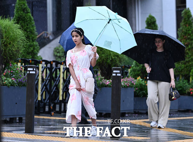 전국에 장맛비가 내리는 21일 서울 시청 일대에서 한 외국인 여학생이 비를 피해 바짓단을 끌어올리고 있다. /이새롬 기자