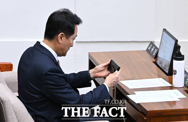 오세훈 서울시장이 21일 오후 서울 중구 서울시의회 본회의장에서 열린 제338회 임시회 제1차 본회의에 참석해 휴대전화 화면을 거울삼아 용모를 살피고 있다.
