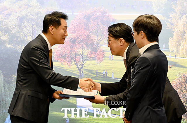 당선작 ‘함께 가꾸는 여의도공원’ 제안한 사람과나무㈜, ㈜제이더블유랜드스케이프, ㈜건축사사무소 협동원 공동팀에 시상하는 오 시장(왼쪽).
