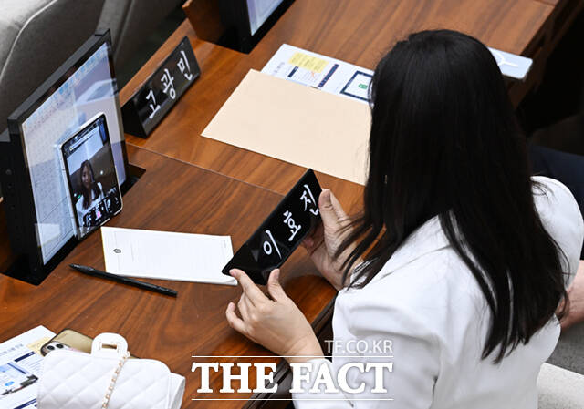 이효진 국민의힘 서울시의원이 21일 오후 서울 중구 서울시의회 본회의장에서 열린 제338회 임시회 제1차 본회의에 참석해 휴대전화로 자신의 이름이 적힌 명패와 함께 기념촬영하고 있다. /이새롬 기자