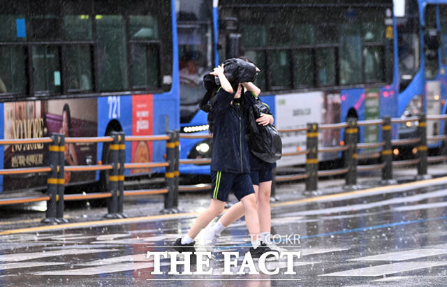 전국에 장맛비가 내리는 21일 서울 시청 일대에서 한 외국인 여학생이 비를 피해 바짓단을 끌어올리고 있다. /이새롬 기자