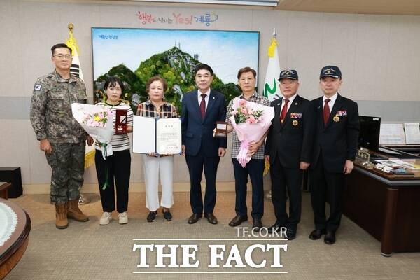 이응우 계룡시장이 21일 시청 시장 집무실에서 열린 '6·25전쟁 화랑무공훈장 전수식'에 참석한 김홍빈 육군본부 6·25 무공훈장 찾아주기 조사단장(왼쪽), 서동옥 대한민국무공수훈자회 충남지부 계룡시지회장(가운데), 이명원 사무국장과 함께 기념 촬영을 하고 있다. /계룡시
