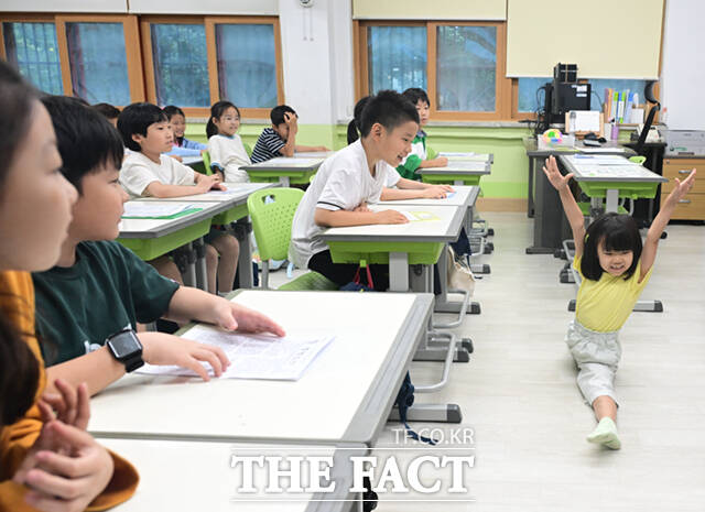 22일 오후 서울 노원구 중평초등학교 2학년 2반 어린이들이 여름방학식에서 생활계획표가 담긴 부채를 들어보이고 있다.