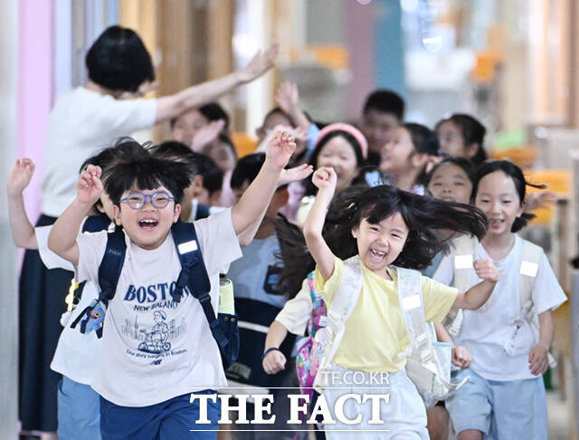 22일 오후 서울 노원구 중평초등학교 2학년 2반 어린이들이 여름방학식에서 생활계획표가 담긴 부채를 들어보이고 있다.