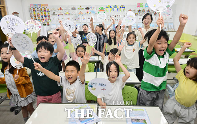 22일 오후 서울 노원구 중평초등학교 2학년 2반 어린이들이 여름방학식에서 생활계획표가 담긴 부채를 들어보이고 있다.