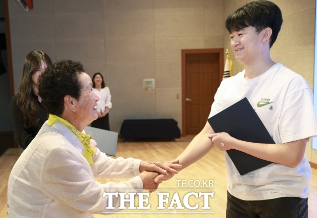김의순 할머니가 학생에게 장학금을 전달하고 격려를 하고 있다. /영암군