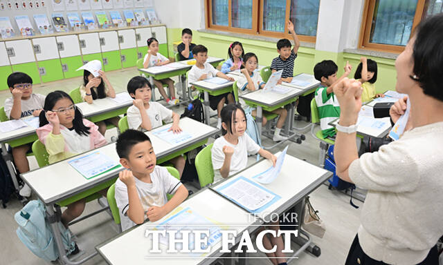 22일 오후 서울 노원구 중평초등학교 2학년 2반 어린이들이 여름방학식에서 생활계획표가 담긴 부채를 들어보이고 있다.