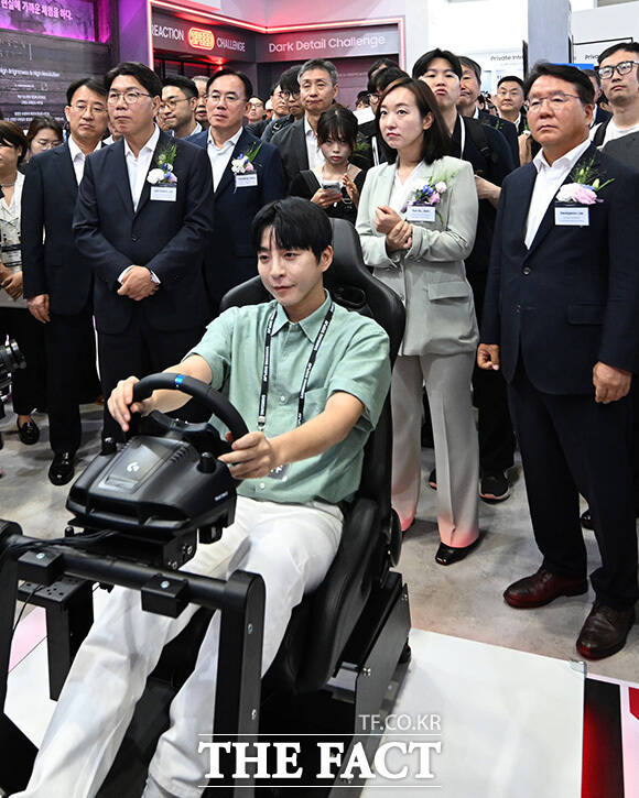 이재관 의원과 전은수 의원이 삼성 디스플레이 제품으로 진행되는 레이싱 게임 장면을 바라보고 있다.