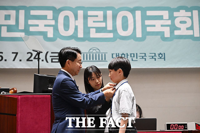 조정식 국회의장이 어린이 국회의원에게 의원배지를 달아주고 있다.