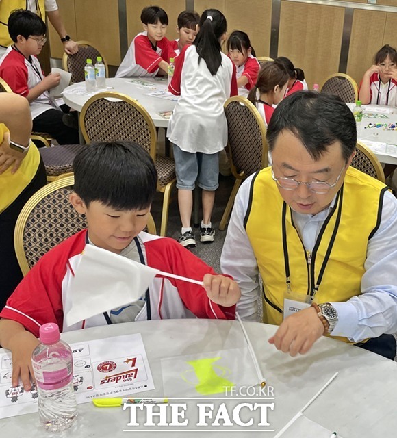 한국스포츠레저(주) 김대욱 대표이사가 드림데이 활동에 참여해 아이들의 응원 굿즈인 미니 깃발을 만드는 것을 도와주고 있다./한국스포츠레저