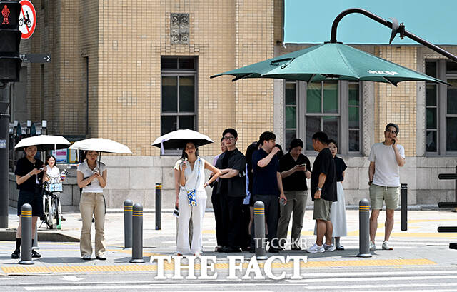 광화문 광장 인근 횡단보도에서 시민들이 햇볕을 피하고 있다.
