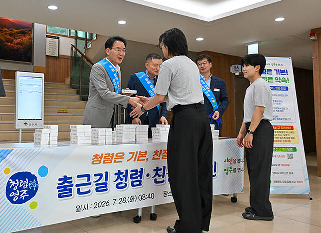 황병직 영주시장(왼쪽)이 출근하는 직원들에게 청렴·친절 실천 메시지가 담긴 홍보물을 나눠주고 있다. /영주시