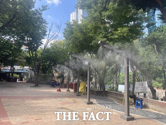 서울 용산구 동자동 쪽방촌 인근 새꿈어린이공원에 설치된 쿨링포그 아래 주민들이 더위를 피하고 있다. /진주영 기자