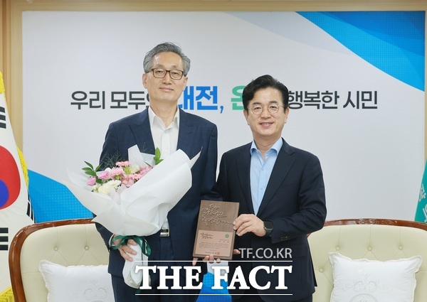 허태정 대전시장(오른쪽)이 31일 행정안전부 전보 발령에 따라 대전시 근무를 마무리한 유득원 대전시 행정부시장(왼쪽)에게 꽃다발을 전달하며 격려하고 있다. /대전시