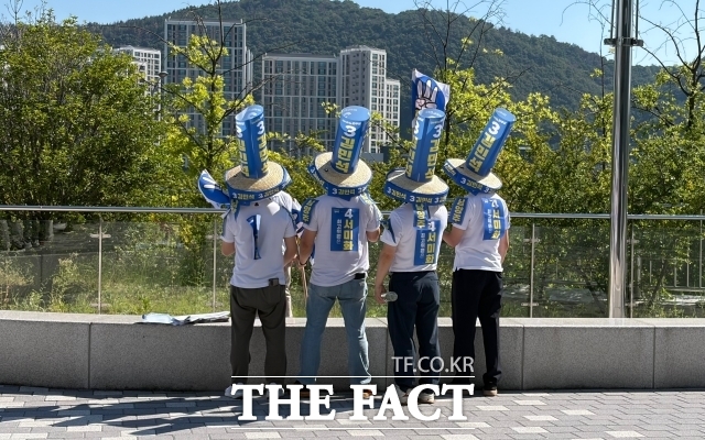더불어민주당 8·17 전당대회 순회경선이 열린 2일 오전 울산전시컨벤션센터 앞에서 김민석 당대표 후보자 지지자들이 모자를 맞춰 쓰고 단체사진을 찍고 있다. /울산=정채영 기자