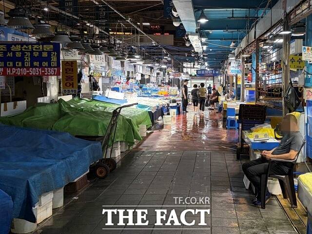 서울 마포구 마포농수산물시장의 한 생선 가게 앞에서 상인이 휴대전화를 바라보며 손님을 기다리는 모습. /이예리 기자