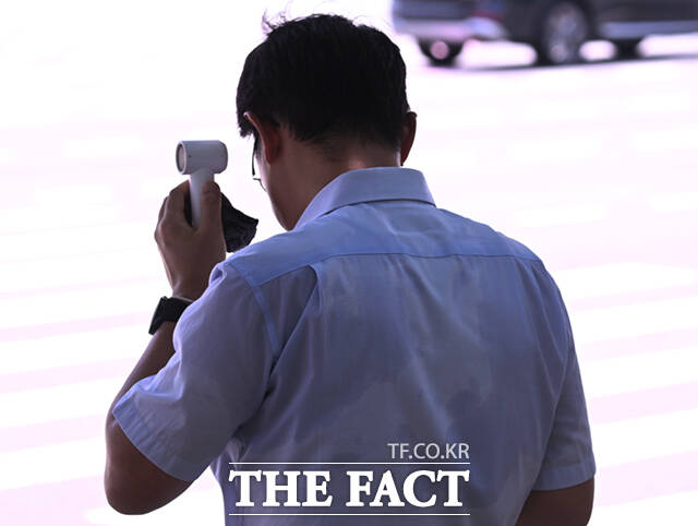 손풍기와 손수건으로 더위를 식혀보지만 이미 땀으로 젖은 셔츠.