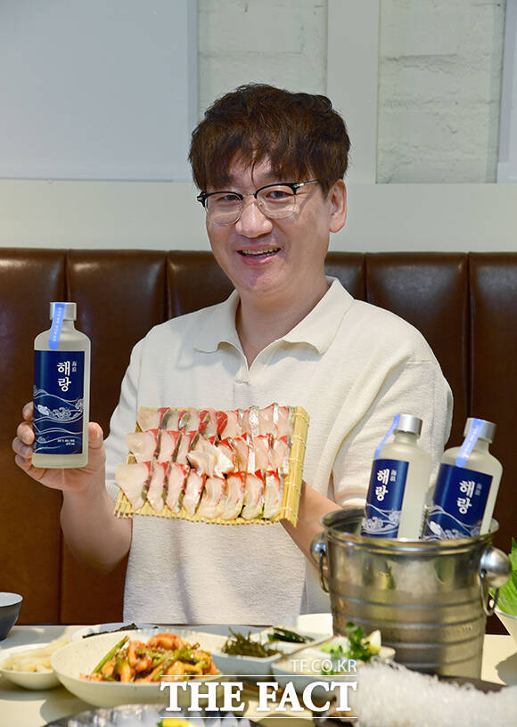수산물 전문 콘텐츠 크리에이터 '입질의추억' 김지민 작가가 전통주 큐레이션 플랫폼 대동여주도와 협업한 수산물 페어링 소주 '해랑'과 출시 기념 촬영을 하고 있다. /대동여주도