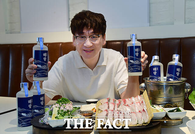 수산물 전문 콘텐츠 크리에이터 '입질의추억' 김지민 작가가 전통주 큐레이션 플랫폼 대동여주도와 협업한 수산물 페어링 소주 '해랑'과 출시 기념 촬영을 하고 있다. /대동여주도
