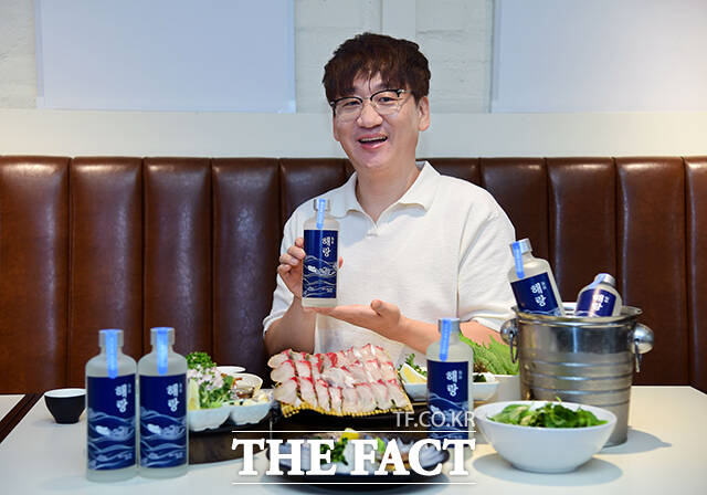 수산물 전문 콘텐츠 크리에이터 '입질의추억' 김지민 작가가 전통주 큐레이션 플랫폼 대동여주도와 협업한 수산물 페어링 소주 '해랑'과 출시 기념 촬영을 하고 있다. /대동여주도