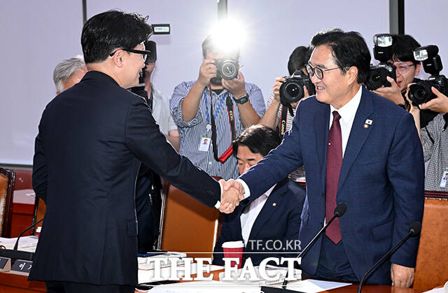 우원식 더불어민주당 의원(오른쪽)과 악수하는 한 의원.