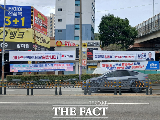 11일 부산시 수영구 일대에 더불어민주당 수영구지역위원회 측과 정연욱 국민의힘 의원 측이 게시한 현수막이 나란히 걸려 있다. /독자 제공