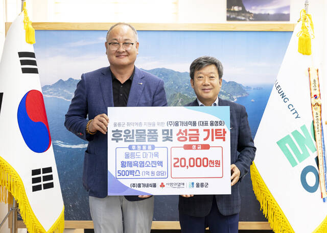 홍성호 홍가네식품 대표(왼쪽)가 남한권 울릉군수에게 지역 어르신들을 위해 1억 2000만 원 상당의 후원 물품과 성금을 기탁하고 있다. /울릉군