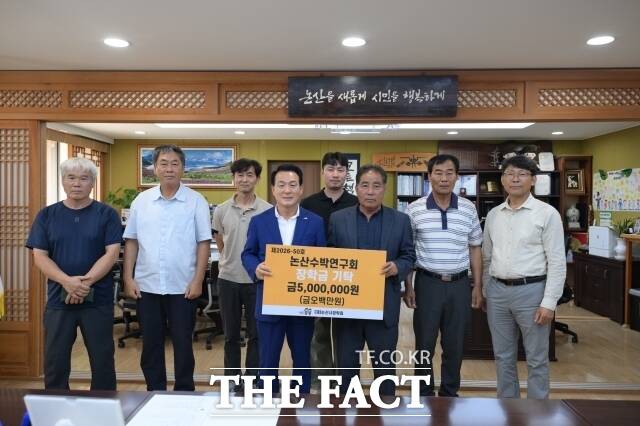 김종일 논산수박연구회 영농조합법인 대표(오른쪽)가 12일 논산시청에서 백성현 논산시장에게 논산시장학회에 장학금으로 500만원을 기탁하고 있다. /논산시